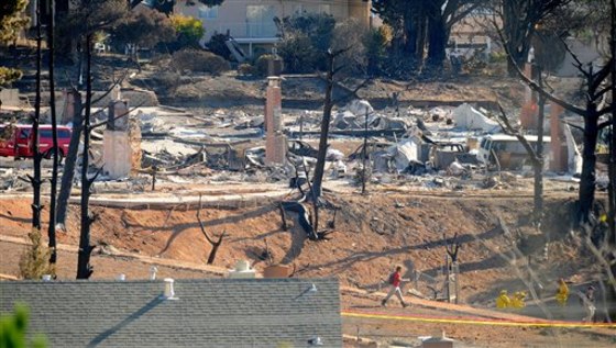 An emergency worker walks through an area of burned homes in San Bruno, Calif., on Saturday.